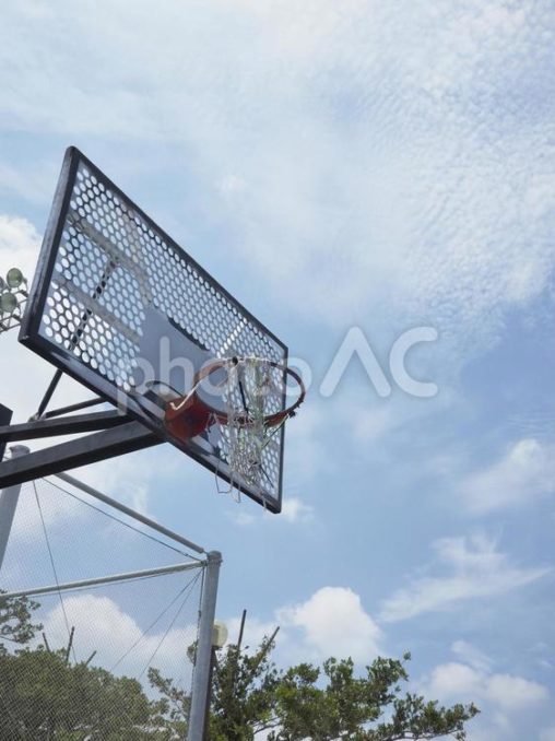 網が破れたバスケットボールリングと空
