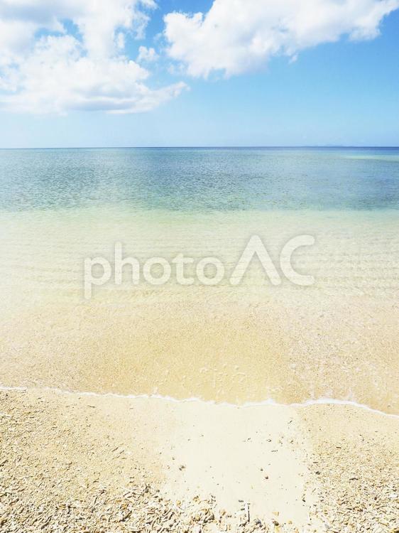 青空と白い雲、砂浜の波打ち際